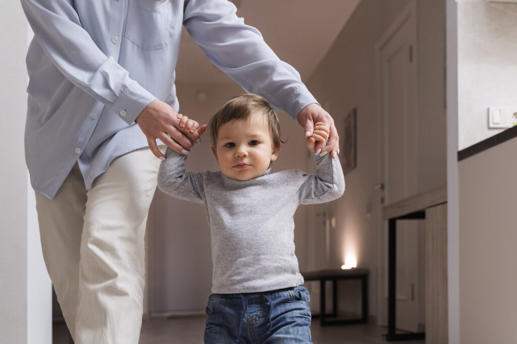 front-view-woman-holding-kid-s-hands-home