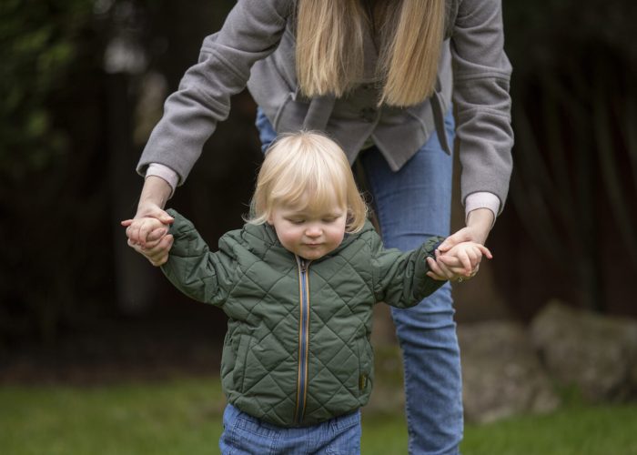 woman-helping-kid-walk-nature